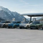 Modern electric SUVs from leading brands parked together with mountains and a charging station in the background.